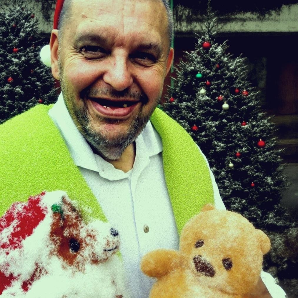 Krzysztof Kononowicz w otoczeniu ludzi, być może podczas wydarzenia publicznego, oddający chaotyczną naturę jego internetowej sławy.