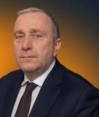 Grzegorz Schetyna przemawiający na wiecu politycznym, z widownią w tle.