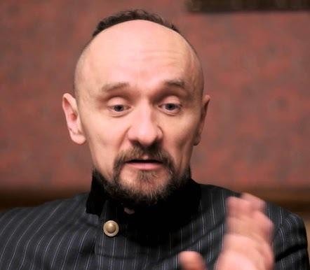 Scena teatralna z dynamiczną inscenizacją w stylu Jana Klaty, z wykorzystaniem kontrastowego oświetlenia i nowoczesnej scenografii.