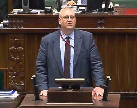 Zbliżenie na twarz Bogdana Święczkowskiego, ukazujące jego poważny i zdeterminowany wyraz.