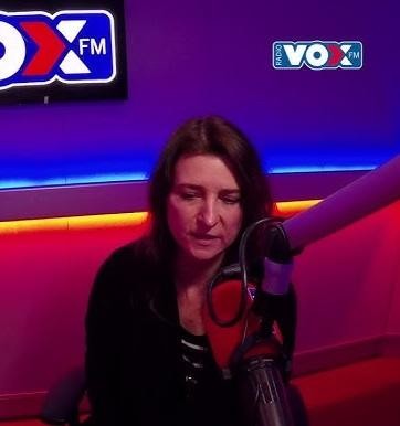 Renata Dąbkowska śpiewająca na scenie, w dynamicznej pozie z mikrofonem, oświetlona dramatycznym światłem.