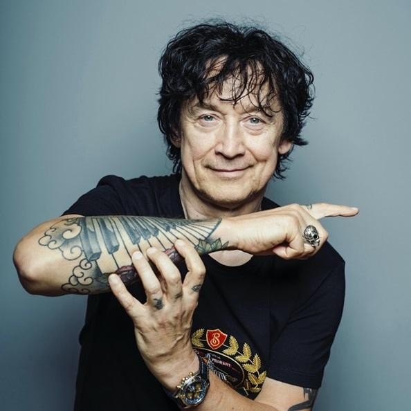 Jan Borysewicz w trakcie występu, z bliska grający na gitarze elektrycznej, ukazujący jego zaangażowanie i energię na scenie.