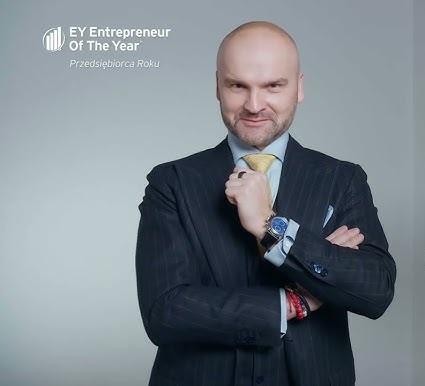 Rafał Brzoska, prezes InPostu, w strategicznej pozie, symbolizującej jego wpływ na innowacje w logistyce i globalny rozwój firmy.