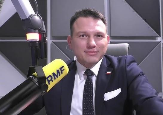 Sławomir Mentzen przemawiający na wiecu wyborczym, z tłumem zwolenników w tle, symbolizujący jego aktywność polityczną i wpływ na scenie publicznej.