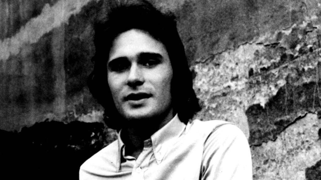 Jerzy Grunwald na scenie we wczesnej karierze, grający na perkusji lub gitarze akustycznej, w otoczeniu zespołu, w stylistyce lat 70.