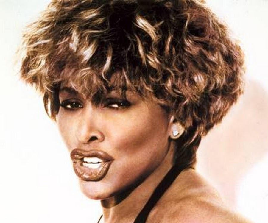 Tina Turner podczas historycznego koncertu na stadionie Maracanã w Rio de Janeiro, z rozłożonymi ramionami, oddająca energię tłumowi, z widocznym ogromem sceny i publiczności.